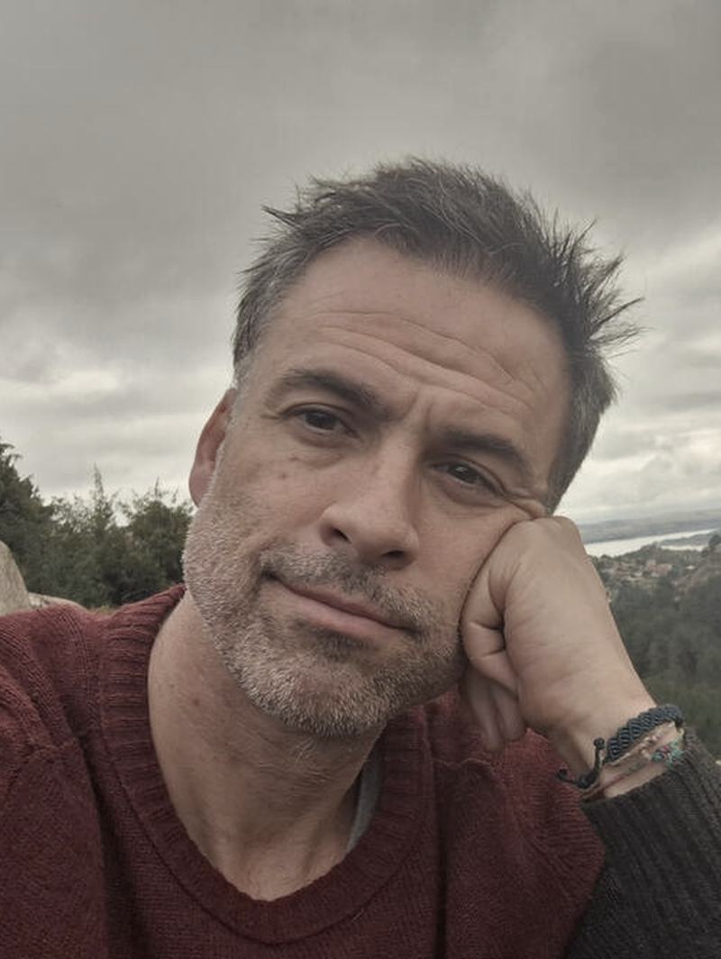 Retrato de Carlos Rico al aire libre, con cielo nublado detrás